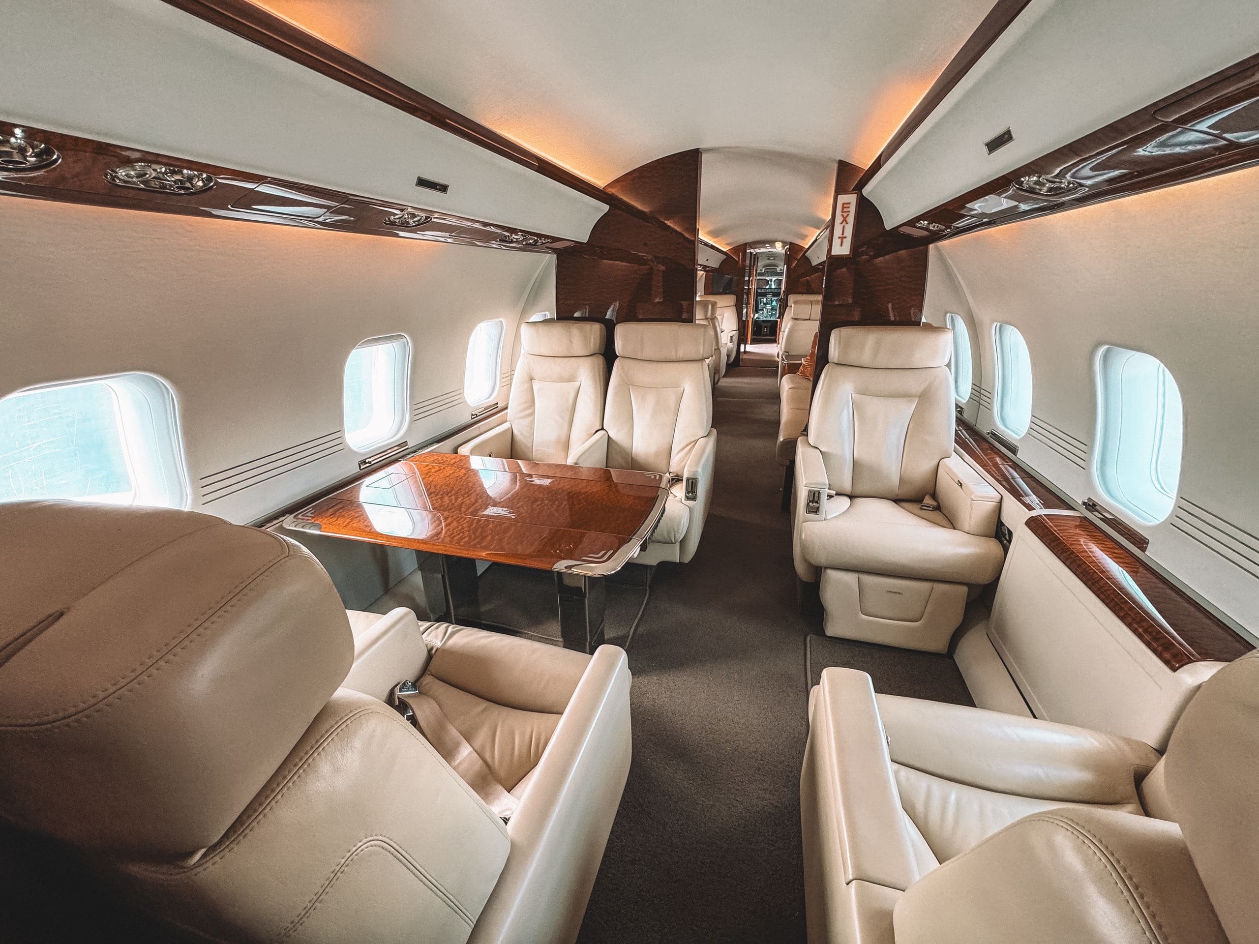 Interior of an empty, immaculately styled private jet cabin at golden hour