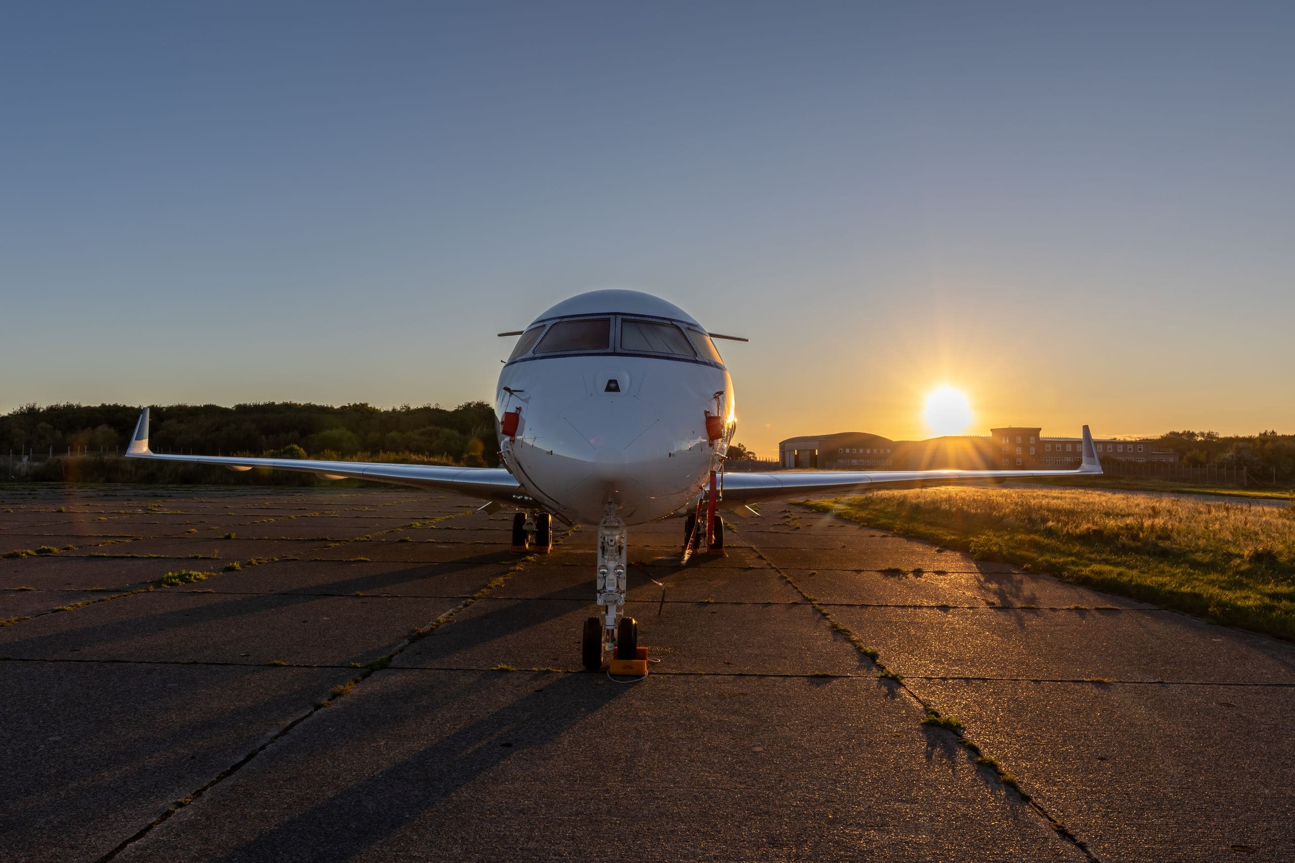 A private jet taxiing alone on an empty runway at dusk without passengers boarding
